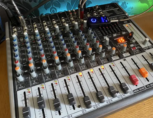 Close-up of a Behringer X1222USB mixer showing the connections for a microphone and tablet for live performance